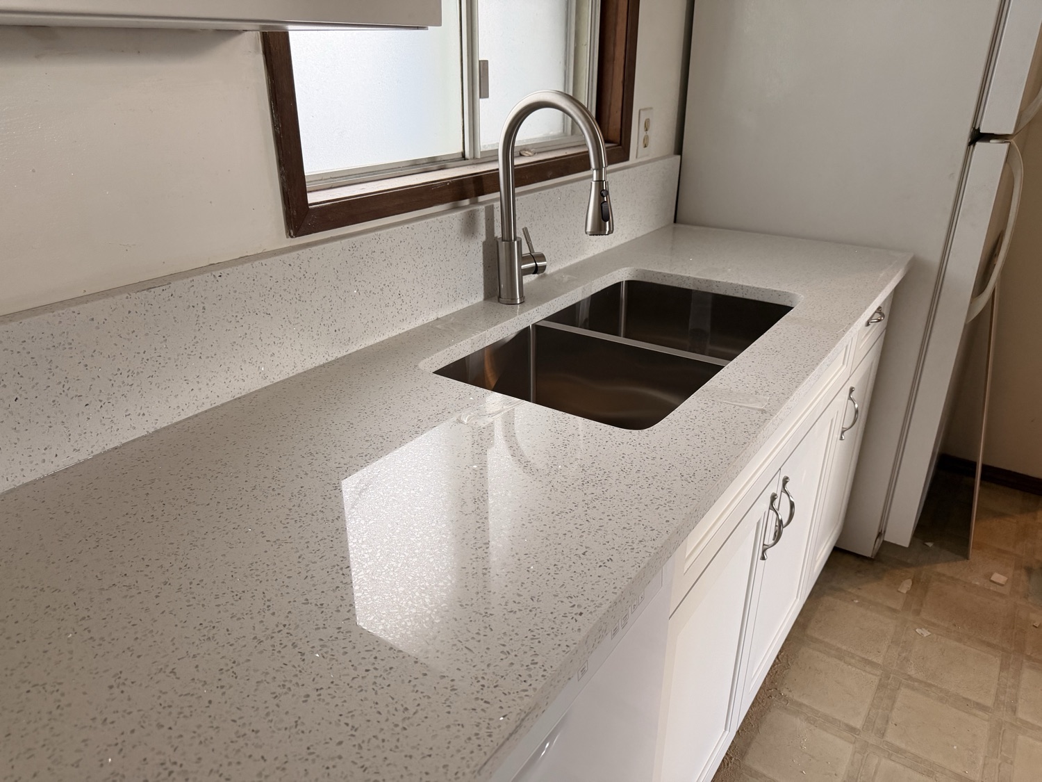 Speckled quartz counter with undermount sink and faucet